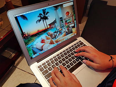 person using MacBook Air displays pool and tree wallpaper thumbnail