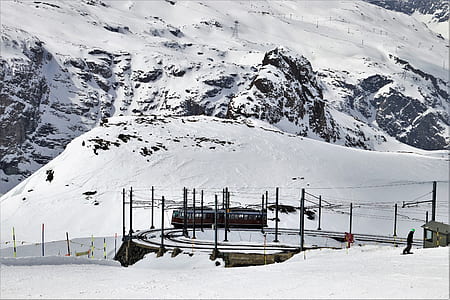 black train near snow covered mountain thumbnail