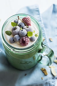 milk filled green glass mason mug topped with blueberries and raspberries thumbnail