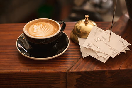 black teacup with saucer on brown table thumbnail