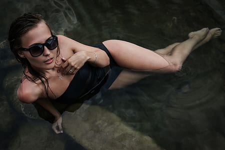 woman black bodysuit with black sunglasses with black frames on body of water thumbnail