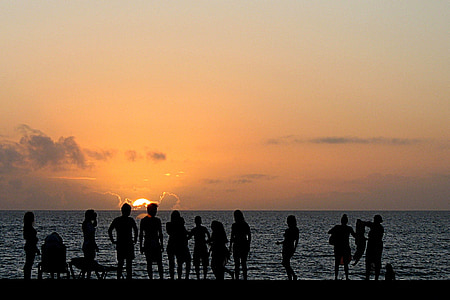 silhouette of people on shore thumbnail
