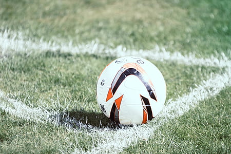 white and black soccer ball on green grass field thumbnail