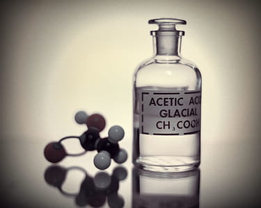 Bottle of acetic acid and the molecular structure. thumbnail