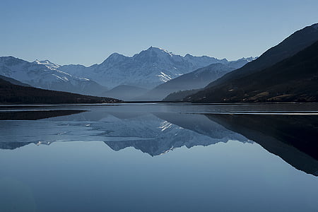 calm body of water near mountains panoramic photo thumbnail