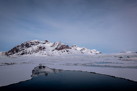 snow covered mountain near body of water thumbnail