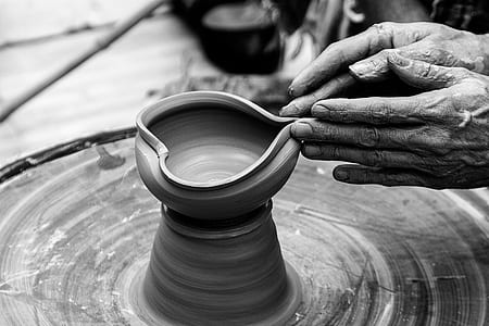 person's hand molding clay vase thumbnail