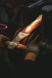 person sharpening axe on belt sander thumbnail