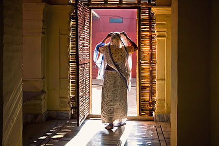 woman standing near brown wooden opened door thumbnail