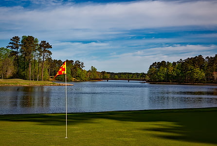 golf course beside lake at daytime thumbnail