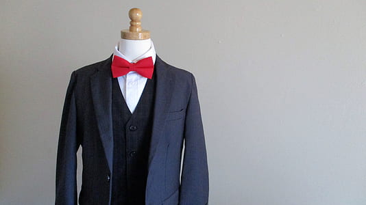 blue suit jacket, red bow tie, white dress shirt on dress form near wall thumbnail