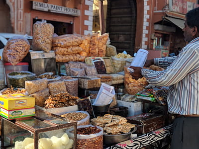 Man In Long-sleeved Shirt Standing Beside Food Stall thumbnail