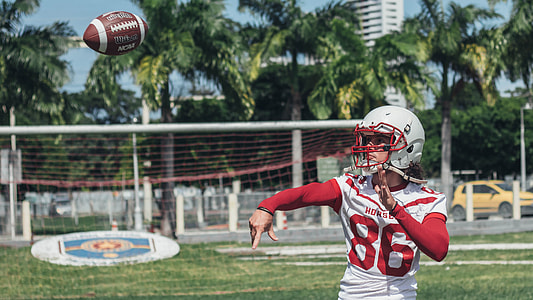 man wearing red and white 86 football jersey throwing football thumbnail