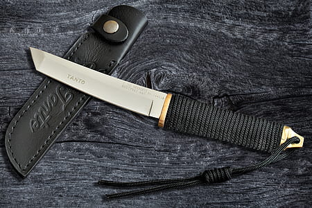 black paracord handled knife with holster on black surface thumbnail