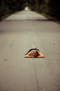 woman planking in the middle of gray road thumbnail