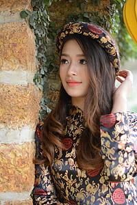 woman leaning on brown wall at daytime thumbnail