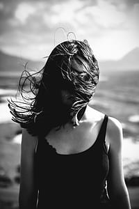 grayscale photography of woman wearing tank top with hair covered in her face thumbnail