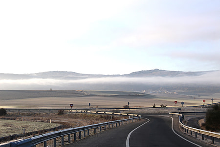 asphalt road heading towards black mountain thumbnail