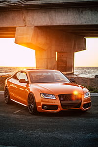 orange Audi coupe parked near concrete bridge thumbnail