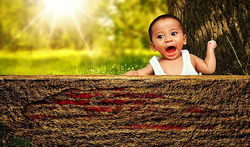 boy wearing white tank top near tree trunk thumbnail