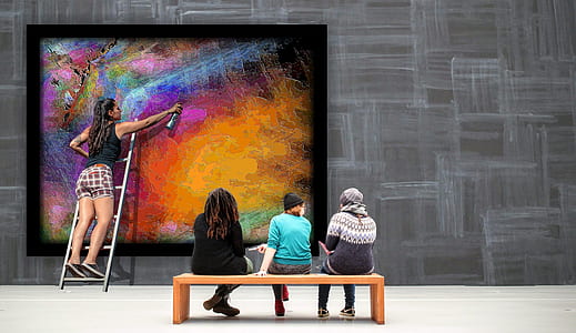 three people sitting near woman painting wall thumbnail