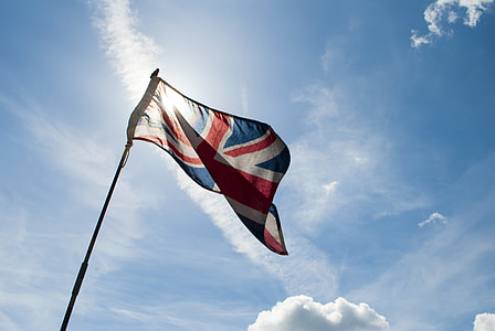 waving flag of Union Jack under white clouds at daytime thumbnail