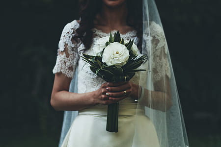 woman wearing wedding dress holding white flower bouquet thumbnail