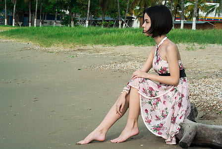 Woman in Pink Floral Halter Dress Seating in Driftwood thumbnail