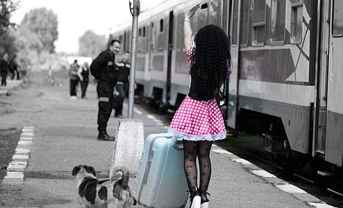 woman standing near street light waving at man selective color photography thumbnail