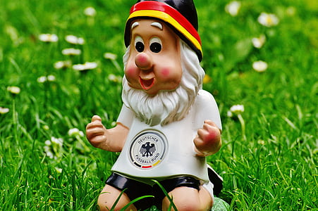 ceramic gnome figurine on green grass thumbnail