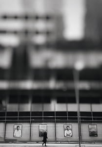 person walking near wall in grayscale photography thumbnail
