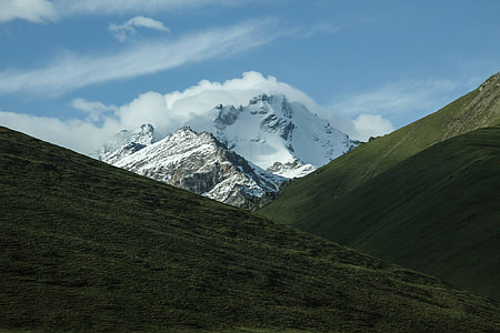 grass covered hills near glacier mountain during day thumbnail