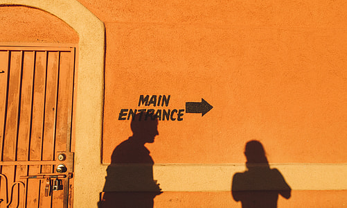 shadow on man and woman on brown concrete wall during daytime thumbnail