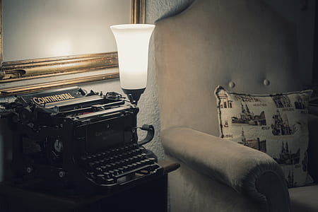 black Continental typewriter on brown wooden end table thumbnail