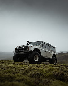 white Land Rover on top of mountain thumbnail