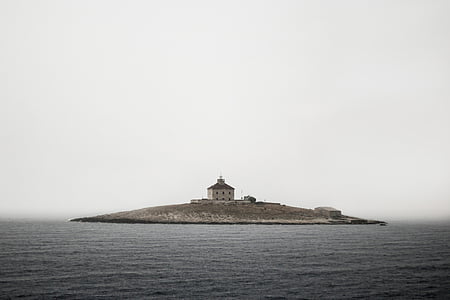 brown concrete building in island at center of body of water thumbnail