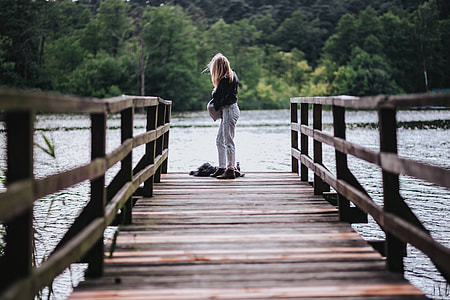 Blonde woman having a healthy snack at the wooden pier thumbnail