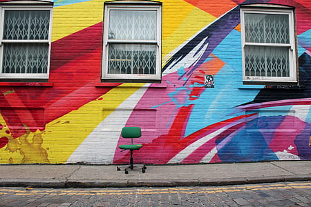 green rolling chair front of wall with graffiti thumbnail