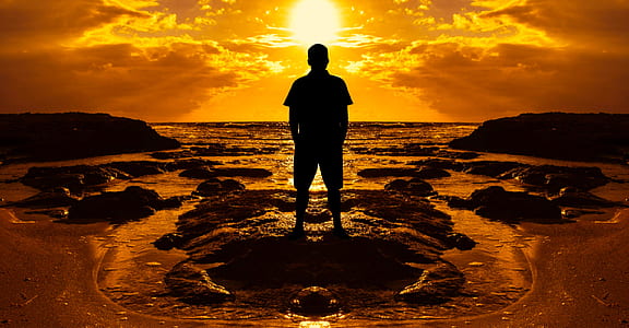 silhouette of a man standing on rock thumbnail