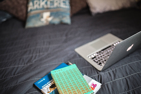 Laptop with books on a bed thumbnail