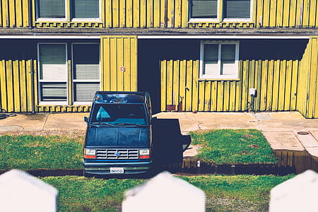 blue Ford truck parked beside yellow house thumbnail