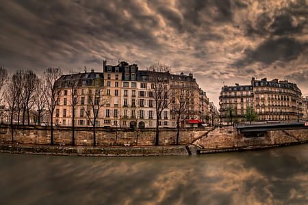 wide angle photo of brown building under cloudy sky thumbnail