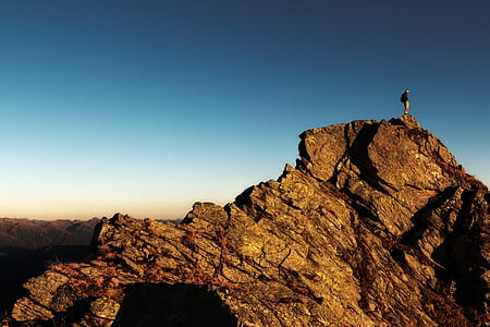 Man Standing on Top of Rock at Daytime thumbnail