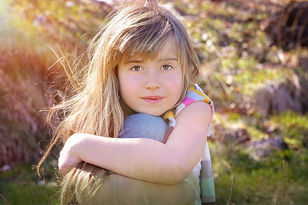 girl sitting on grass during daytime thumbnail