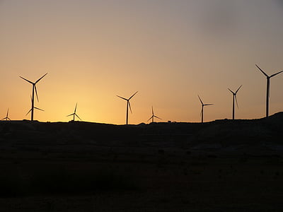 silhouette of wind mills during golden hour thumbnail
