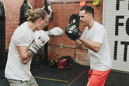 man training boxing with man wearing punch pads thumbnail
