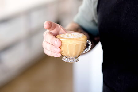 person holding cup of coffee art thumbnail