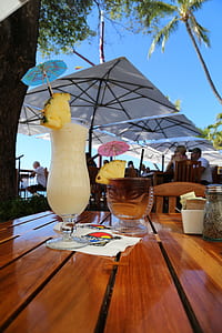 white and brown beverages inside clear glass cups on brown wooden table thumbnail