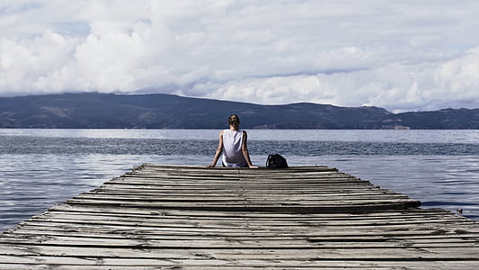 person sitting on beach dock thumbnail