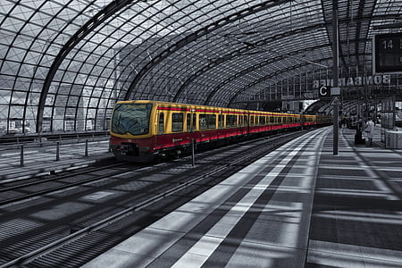 selective color photography of yellow train inside train station thumbnail